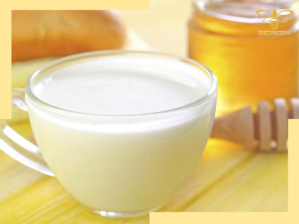 یک لیوان شیر که آماده است تا عسل در آن ریخته شود